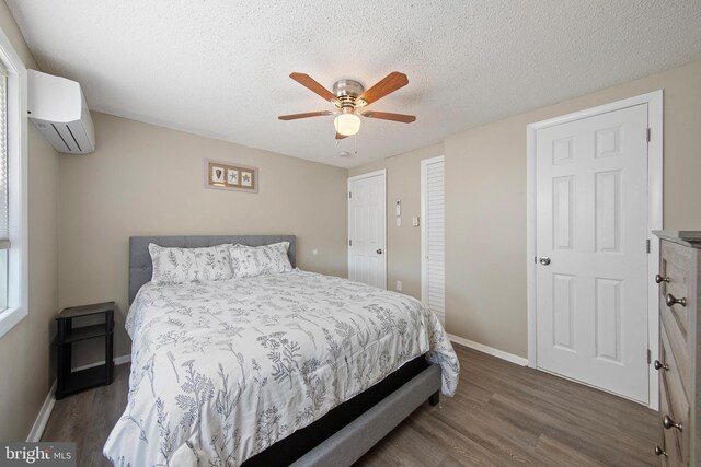 5909 Ocean Blvd, Long Beach Township, NJ 08008 - bedroom with baseboards, a textured ceiling, an AC wall unit, and wood finished floors