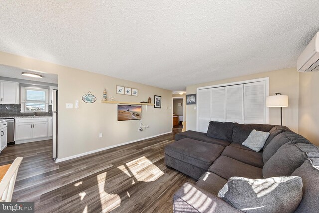 5909 Ocean Blvd, Long Beach Township, NJ 08008 - living room with dark wood finished floors, an AC wall unit, baseboards, and a textured ceiling