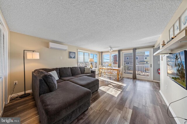 5909 Ocean Blvd, Long Beach Township, NJ 08008 - living area featuring a ceiling fan, wood finished floors, baseboards, an AC wall unit, and a textured ceiling