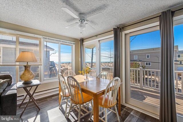 5909 Ocean Blvd, Long Beach Township, NJ 08008 - dining area with ceiling fan, a baseboard heating unit, a textured ceiling, and wood finished floors