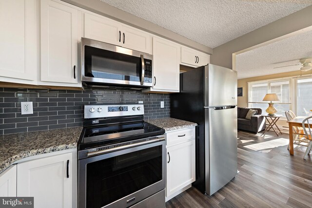 5909 Ocean Blvd, Long Beach Township, NJ 08008 - kitchen with dark wood-type flooring, a textured ceiling, white cabinetry, appliances with stainless steel finishes, and stone counters