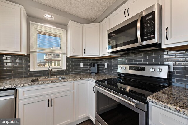 5909 Ocean Blvd, Long Beach Township, NJ 08008 - kitchen with a sink, stainless steel appliances, light stone counters, and white cabinets