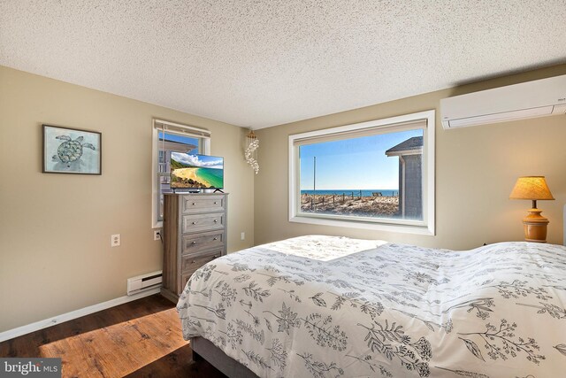5909 Ocean Blvd, Long Beach Township, NJ 08008 - bedroom featuring a wall unit AC, baseboards, dark wood-type flooring, a textured ceiling, and a baseboard heating unit