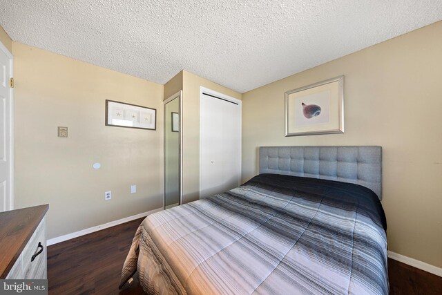 5909 Ocean Blvd, Long Beach Township, NJ 08008 - bedroom with a closet, a textured ceiling, baseboards, and dark wood-style flooring