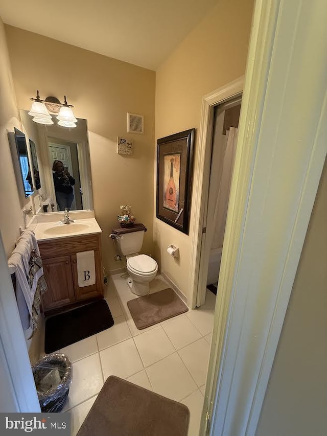 bathroom featuring toilet, vanity, visible vents, and tile patterned floors