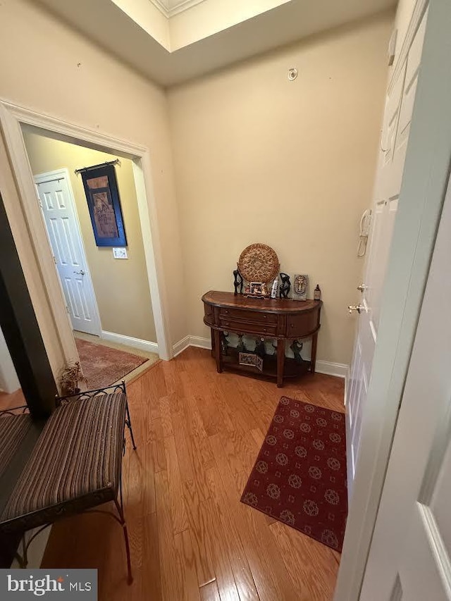 corridor featuring baseboards and wood finished floors