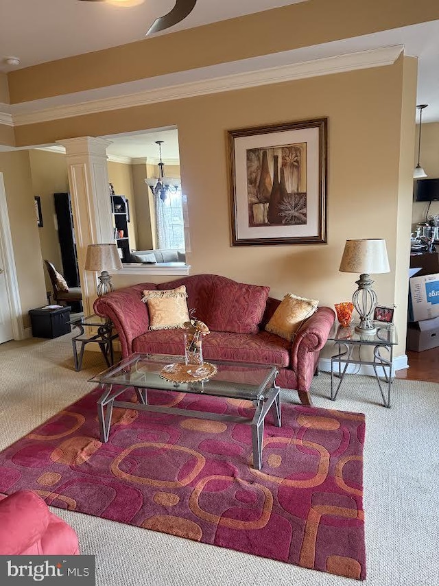 carpeted living room with a chandelier, crown molding, and ornate columns