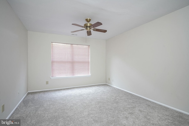 empty room featuring carpet flooring, ceiling fan, and baseboards