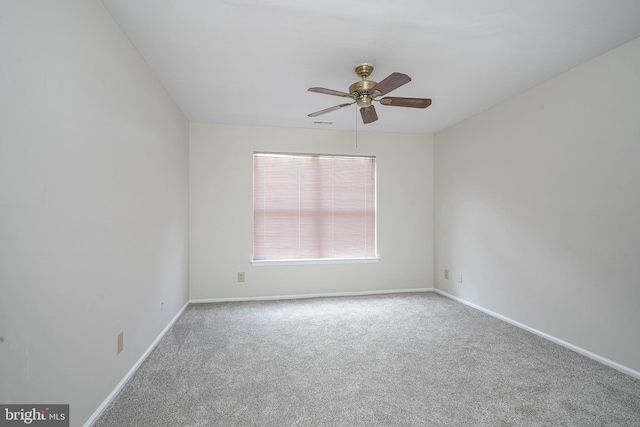 spare room featuring carpet floors, ceiling fan, and baseboards