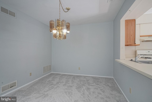 unfurnished dining area featuring carpet, visible vents, and an inviting chandelier