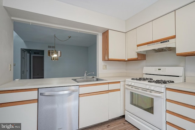 kitchen featuring white range with gas stovetop, under cabinet range hood, a sink, light countertops, and dishwasher