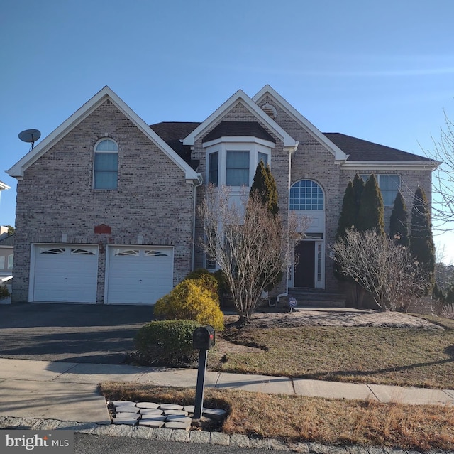 view of front of home with entry steps, an attached garage, brick siding, and driveway