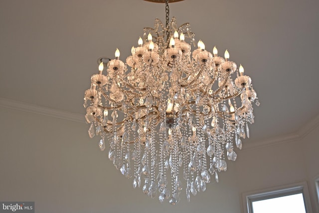 interior details featuring ornamental molding and an inviting chandelier