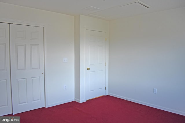 unfurnished bedroom featuring dark colored carpet, a closet, and baseboards