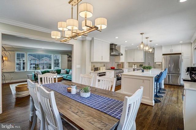 dining space with a chandelier, dark wood finished floors, crown molding, and recessed lighting