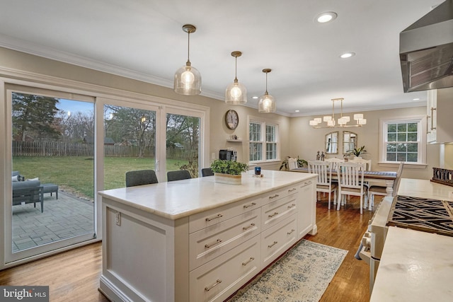 kitchen featuring ornamental molding, light stone countertops, light wood-type flooring, white cabinetry, and recessed lighting