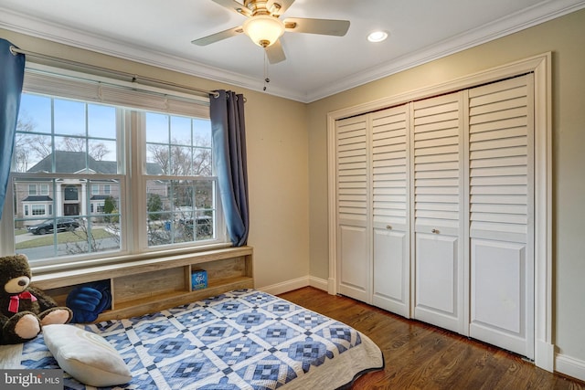 bedroom featuring ceiling fan, dark wood-style flooring, baseboards, a closet, and crown molding