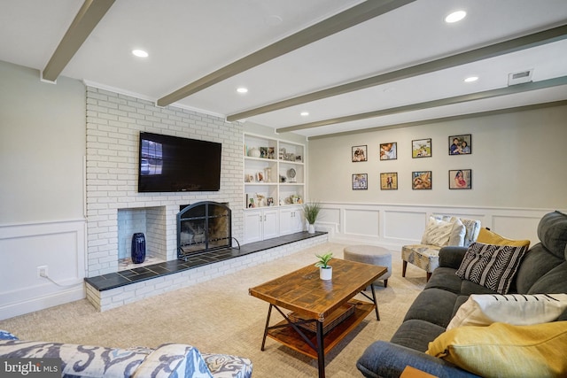 carpeted living area with built in shelves, recessed lighting, a decorative wall, a brick fireplace, and beam ceiling