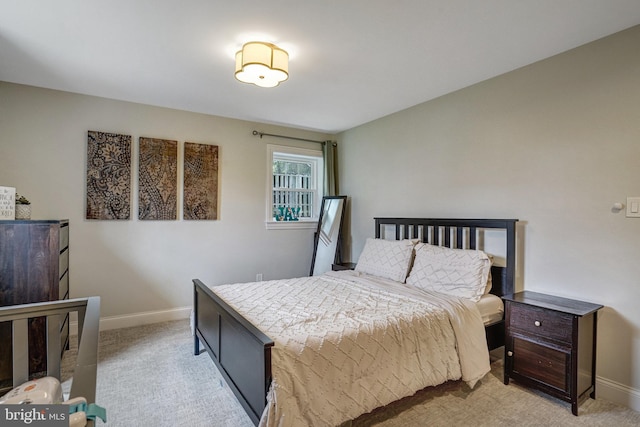 bedroom with light colored carpet and baseboards