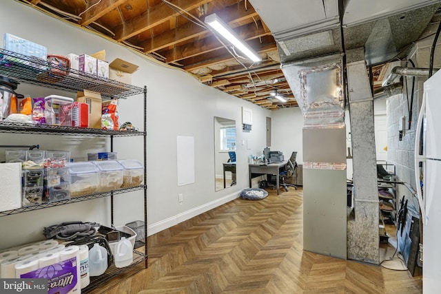 unfinished basement featuring freestanding refrigerator and baseboards