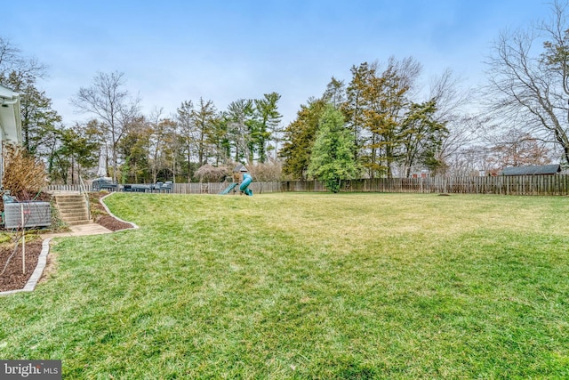 view of yard with a fenced backyard and a playground