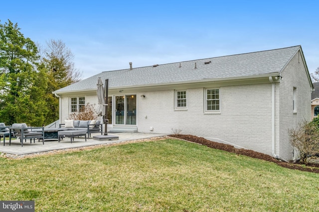 rear view of property featuring a yard, a patio, brick siding, and an outdoor living space