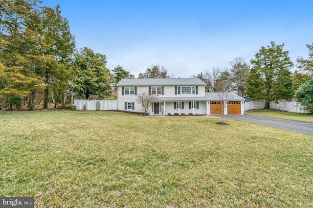 view of front facade with a front lawn, driveway, an attached garage, and fence