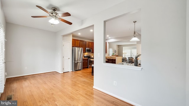 unfurnished living room with recessed lighting, visible vents, a ceiling fan, baseboards, and light wood-type flooring