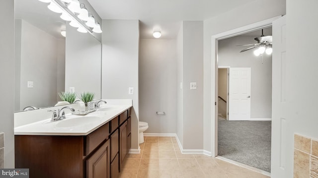 full bathroom featuring ceiling fan, double vanity, a sink, and toilet