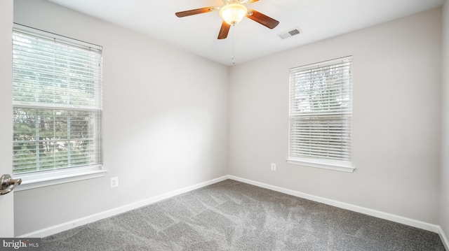 empty room featuring baseboards, visible vents, ceiling fan, and carpet flooring