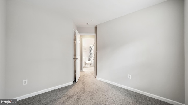 carpeted spare room featuring baseboards