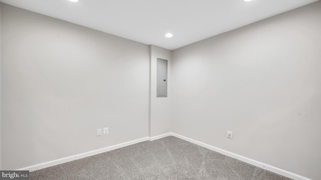 carpeted spare room featuring recessed lighting, electric panel, and baseboards