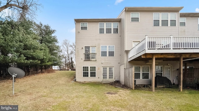 back of house with a deck and a yard