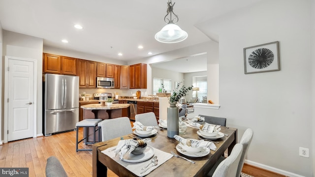 dining area with light wood-style floors, recessed lighting, and baseboards