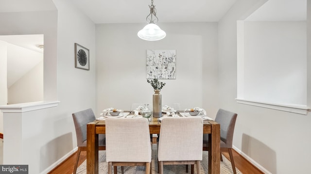 dining area with baseboards and wood finished floors