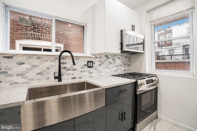 5126 N Sydenham St, Philadelphia, PA 19141 - kitchen featuring white cabinets, baseboards, appliances with stainless steel finishes, backsplash, and marble finish floor