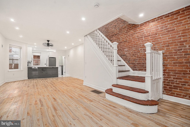 5126 N Sydenham St, Philadelphia, PA 19141 - staircase featuring brick wall, visible vents, baseboards, and wood finished floors