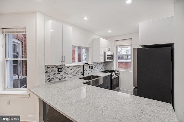 5126 N Sydenham St, Philadelphia, PA 19141 - kitchen with white cabinets, recessed lighting, a sink, stainless steel appliances, and backsplash