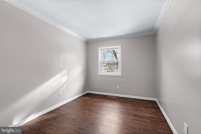 unfurnished room featuring ornamental molding, wood finished floors, visible vents, and baseboards