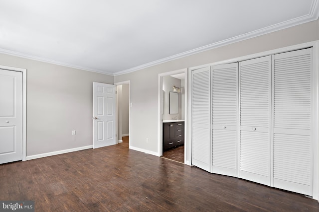 unfurnished bedroom featuring crown molding, connected bathroom, baseboards, and dark wood-style flooring