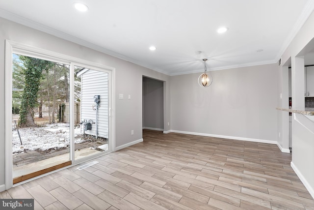 spare room featuring crown molding, recessed lighting, light wood-type flooring, and a notable chandelier