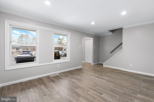 unfurnished room featuring ornamental molding, wood finished floors, and baseboards