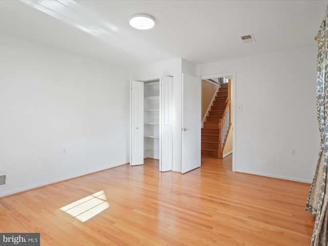 unfurnished bedroom with light wood-style floors, a closet, and baseboards