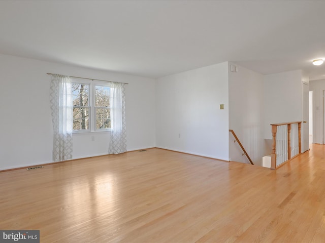 unfurnished room with visible vents and wood finished floors