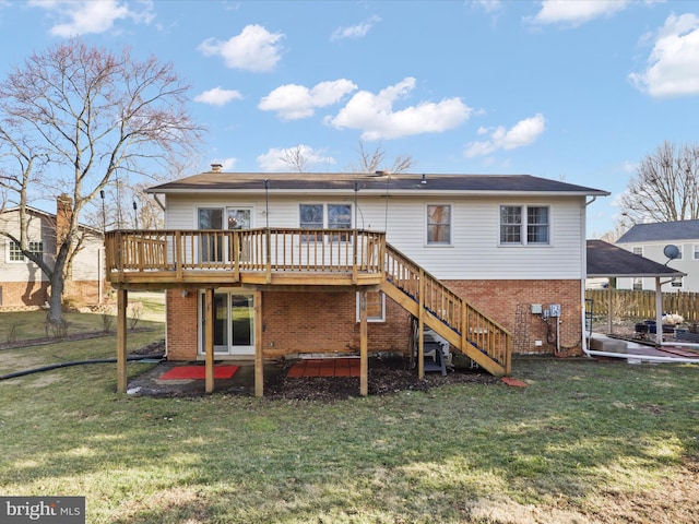 rear view of house featuring a lawn, a deck, a patio, and brick siding