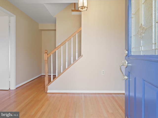 entrance foyer with stairway, wood finished floors, and baseboards