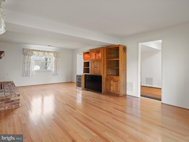 unfurnished living room featuring visible vents and light wood-style flooring