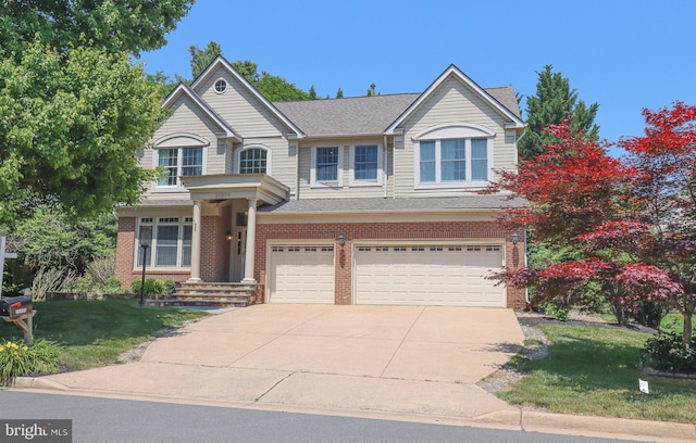 traditional-style house with brick siding, roof with shingles, concrete driveway, a front yard, and a garage