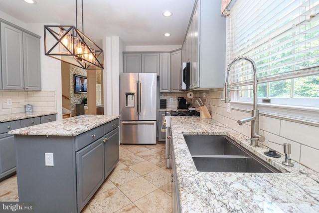 kitchen with stainless steel appliances, a sink, and gray cabinetry