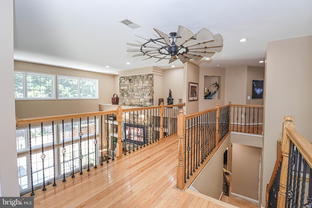 corridor with visible vents, hardwood / wood-style floors, an upstairs landing, and recessed lighting